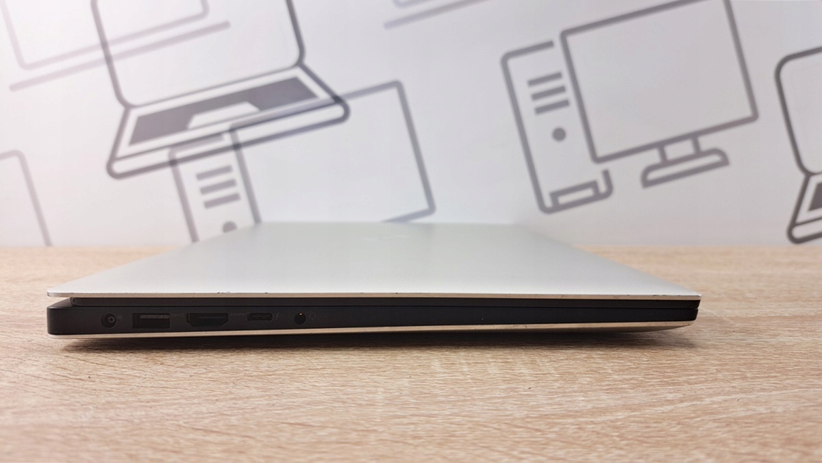 Zamknięty laptop Dell Precision 5530 widziany z boku, cienka obudowa z widocznym portem USB i wyjściem audio.
