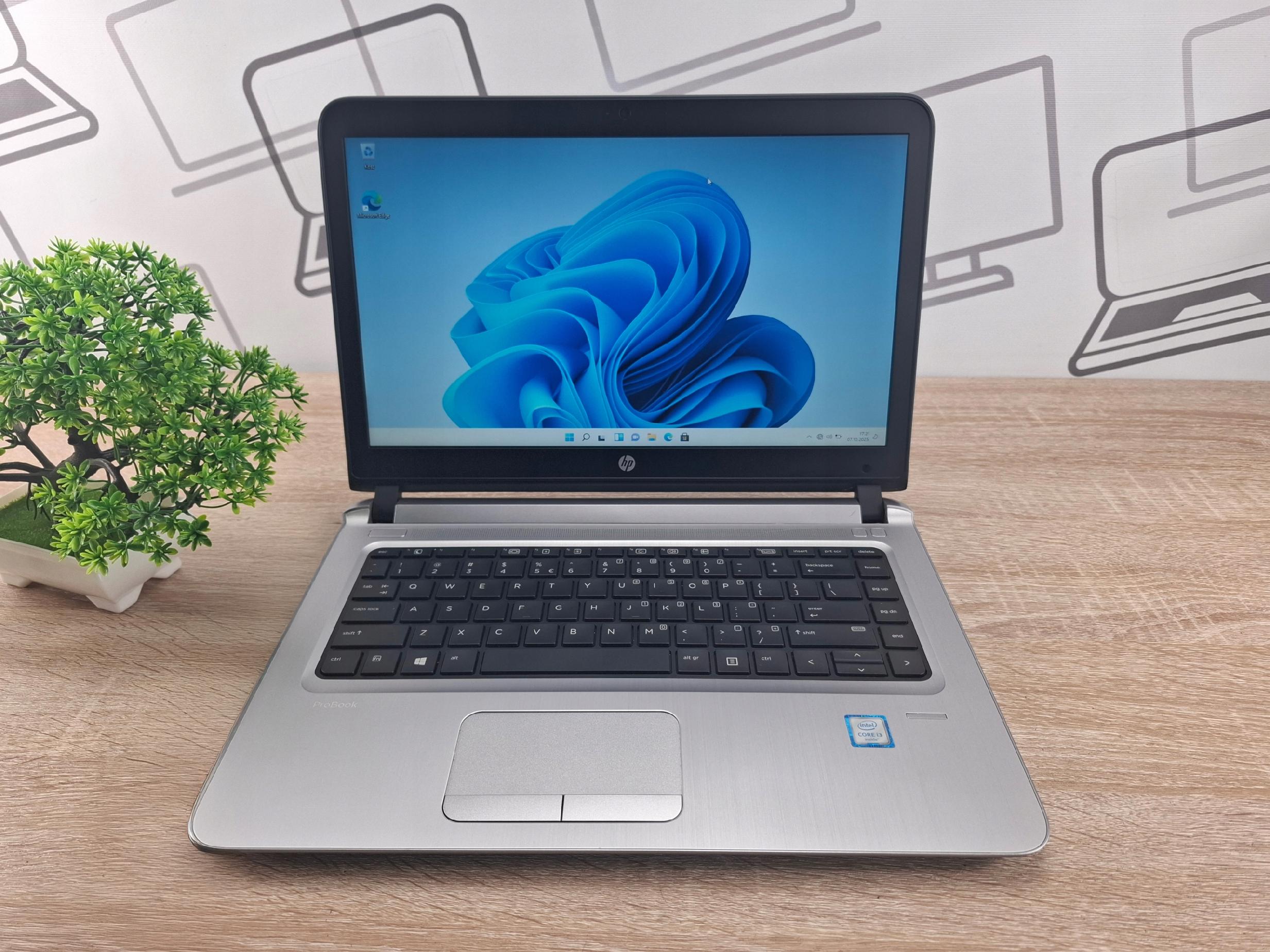 Otwarty laptop HP ProBook 440 G3 widziany z przodu, na ekranie kolorowe logo Windows 11, klawiatura i touchpad widoczne z góry.