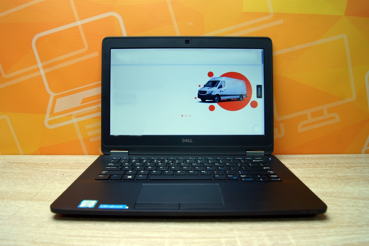 Otwarty laptop Dell pod niewielkim kątem z przodu, ekran włączony z grafiką ikony logistycznej.