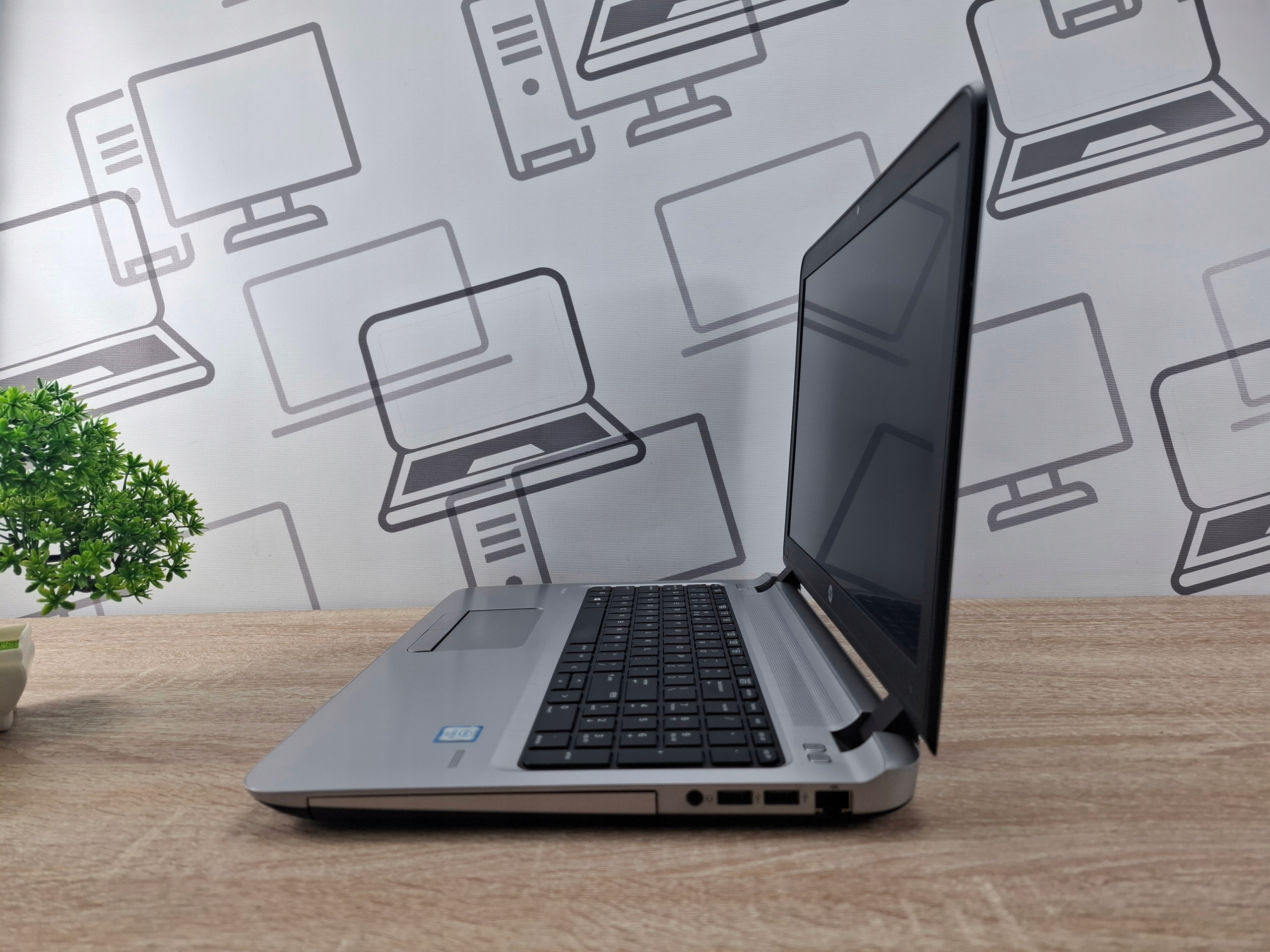 Laptop HP ProBook widoczny z boku pod kątem, ekran uchylony, widoczne porty boczne i klawiatura, obudowa z widocznymi śladami użytkowania.