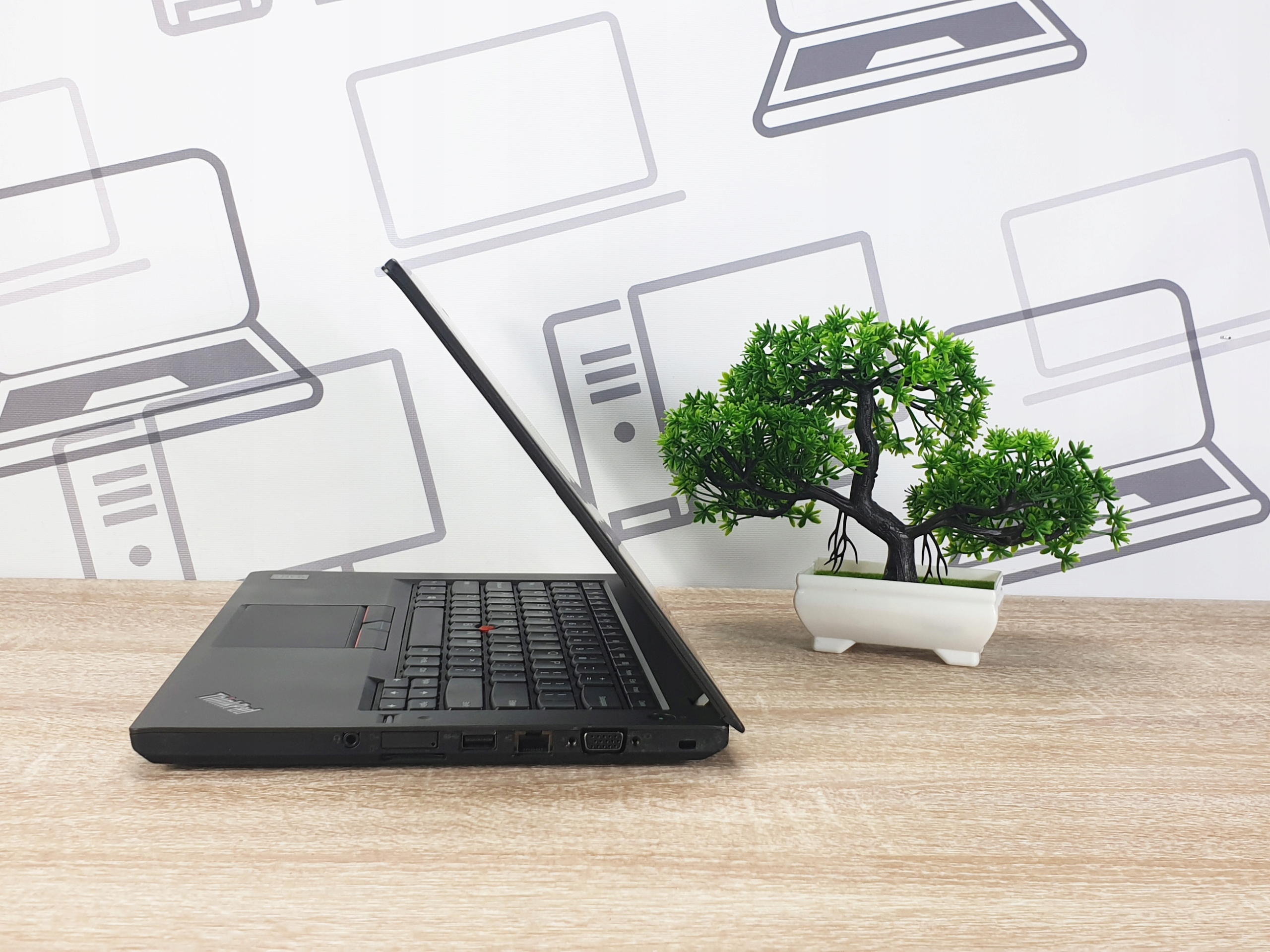 Laptop Lenovo ThinkPad T450 uchylony pod niewielkim kątem, widok z boku na klawiaturę i lewy panel z portami.