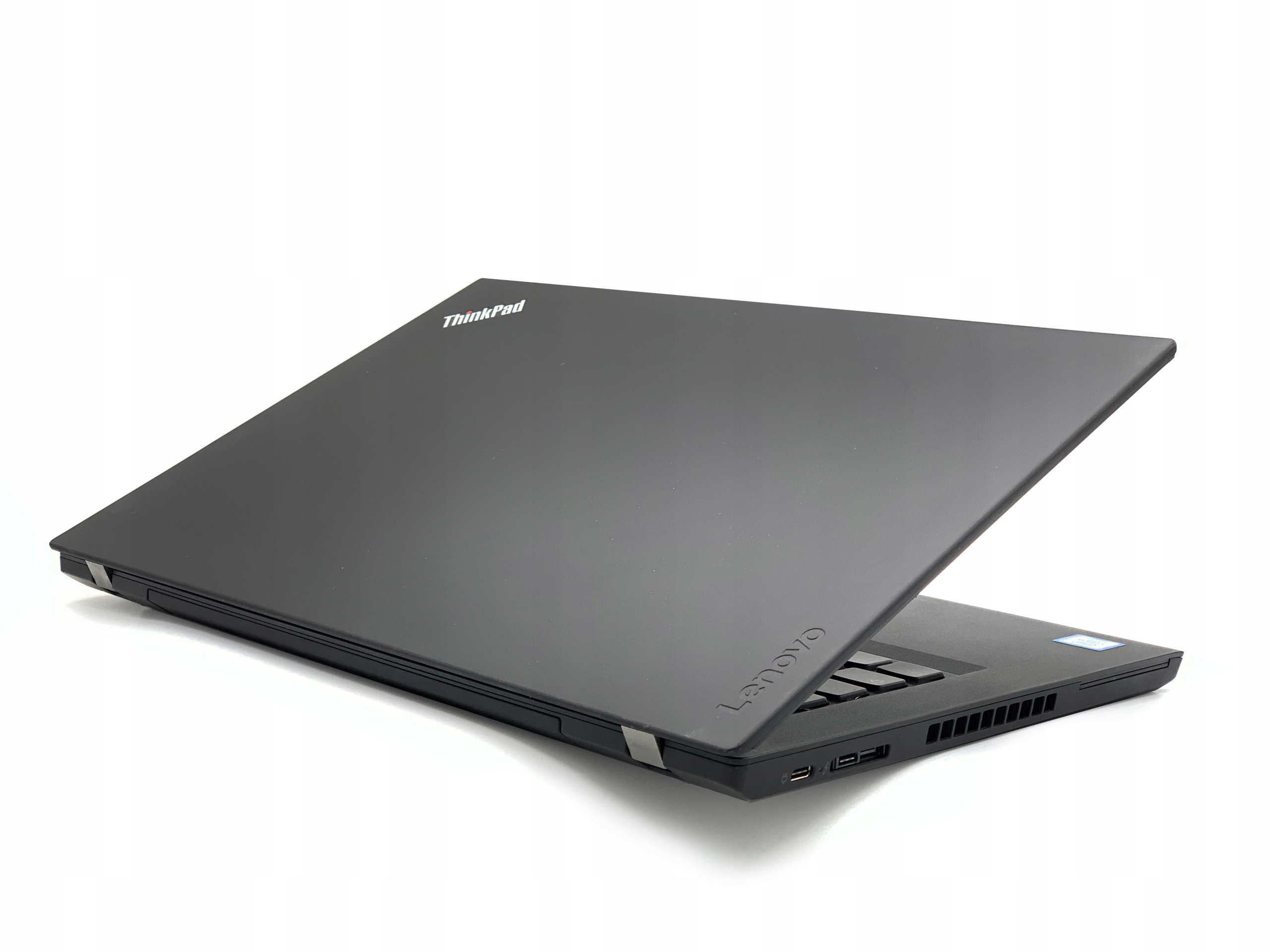 Zamknięty laptop Lenovo ThinkPad widziany od tyłu pod kątem, z logo na klapie i widocznymi zawiasami ekranu.