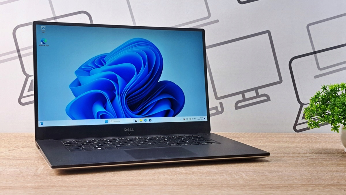 Otwarty laptop Dell Precision 5530 na biurku, ekran włączony z niebieską grafiką systemu Windows.