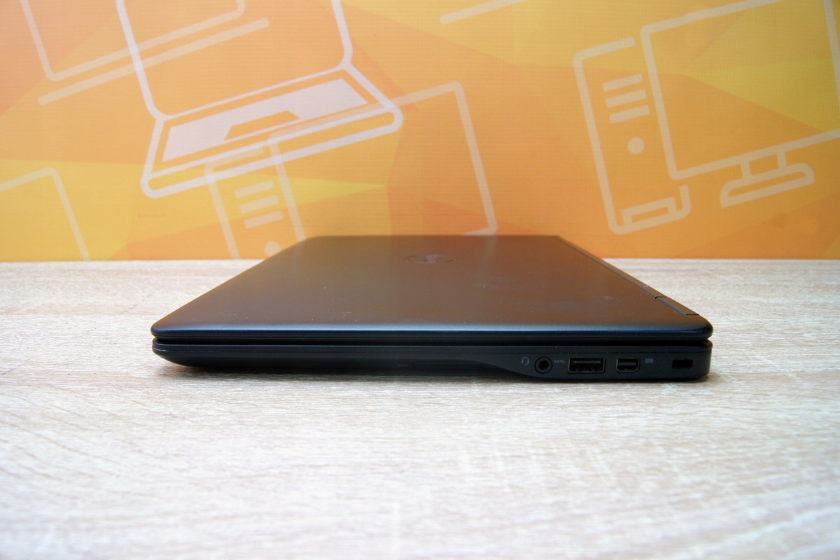 Zamknięty laptop Dell z boku, widoczne porty USB i HDMI na krawędzi obudowy.