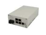 Niewielki switch Nexans w jasnej metalowej obudowie, widok z przodu na porty RJ45 i złącze SC pod kątem.
