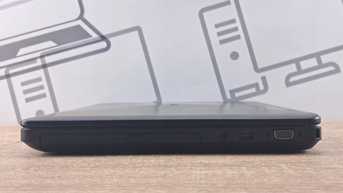 Zamknięty laptop Dell widziany z prawego boku z napędem optycznym oraz portami USB i złączem zasilania