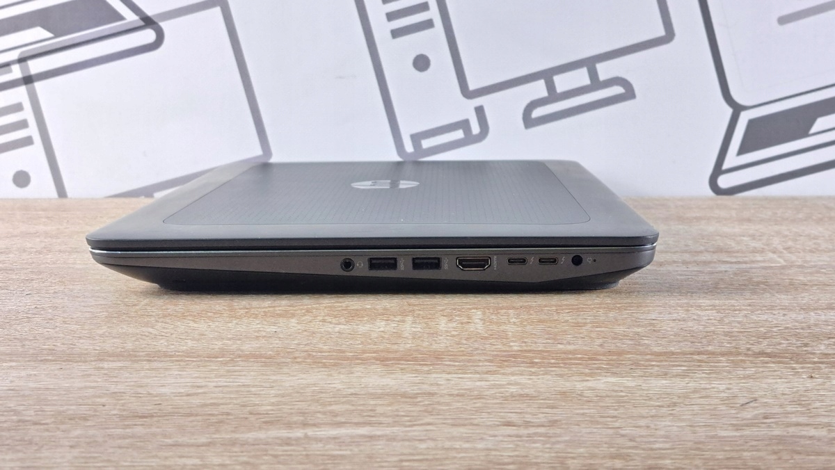 Zamknięty laptop HP ZBook widziany z boku, widoczne porty USB, HDMI i złącze zasilania na krawędzi obudowy.