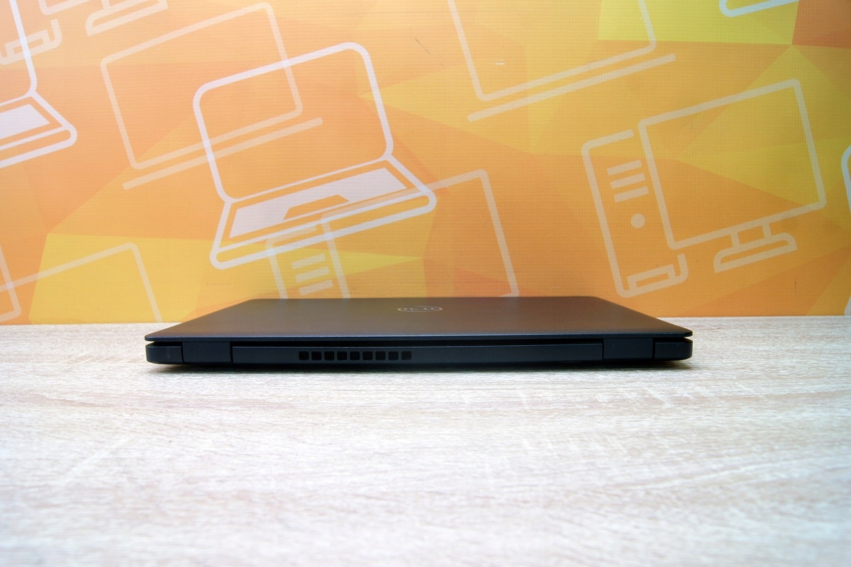 Zamknięty laptop Dell Latitude widziany z boku, prawa krawędź z otworami wentylacyjnymi, obudowa bez widocznych uszkodzeń.