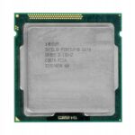 Procesor Intel Pentium G870 widziany z góry, metalowa pokrywa z oznaczeniami i widoczne złocone piny na spodzie płytki.