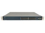 Przedni panel switcha Cisco z 24 portami RJ45, czterema slotami combo SFP i uszami montażowymi po bokach.