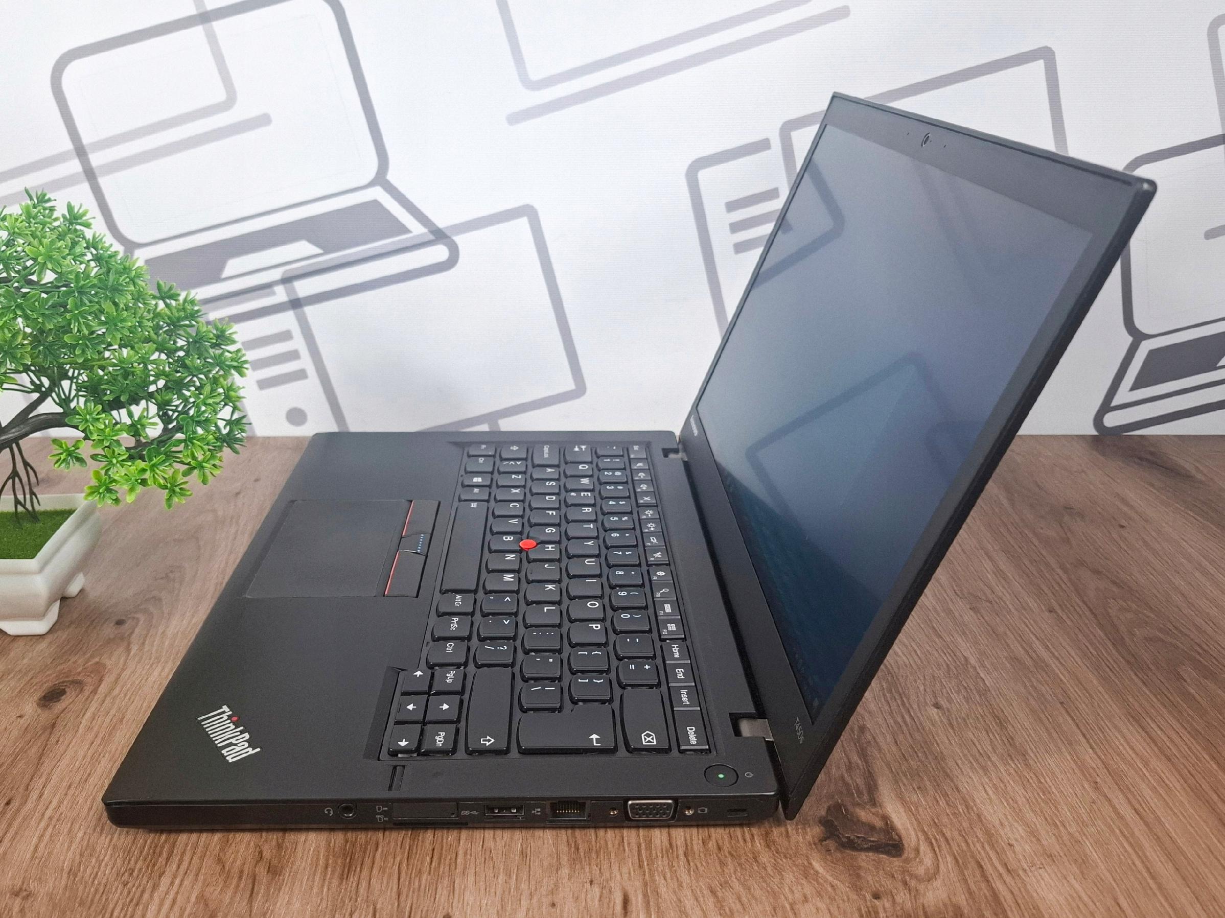 Otwarty laptop Lenovo ThinkPad T450s pod kątem z boku, widok na klawiaturę i wygaszony ekran, obudowa w czarnym kolorze.