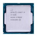 Procesor Intel Core i3-6100 widziany z góry, srebrna metalowa pokrywa z nadrukiem oznaczenia i złote piny na obrzeżu podstawki.