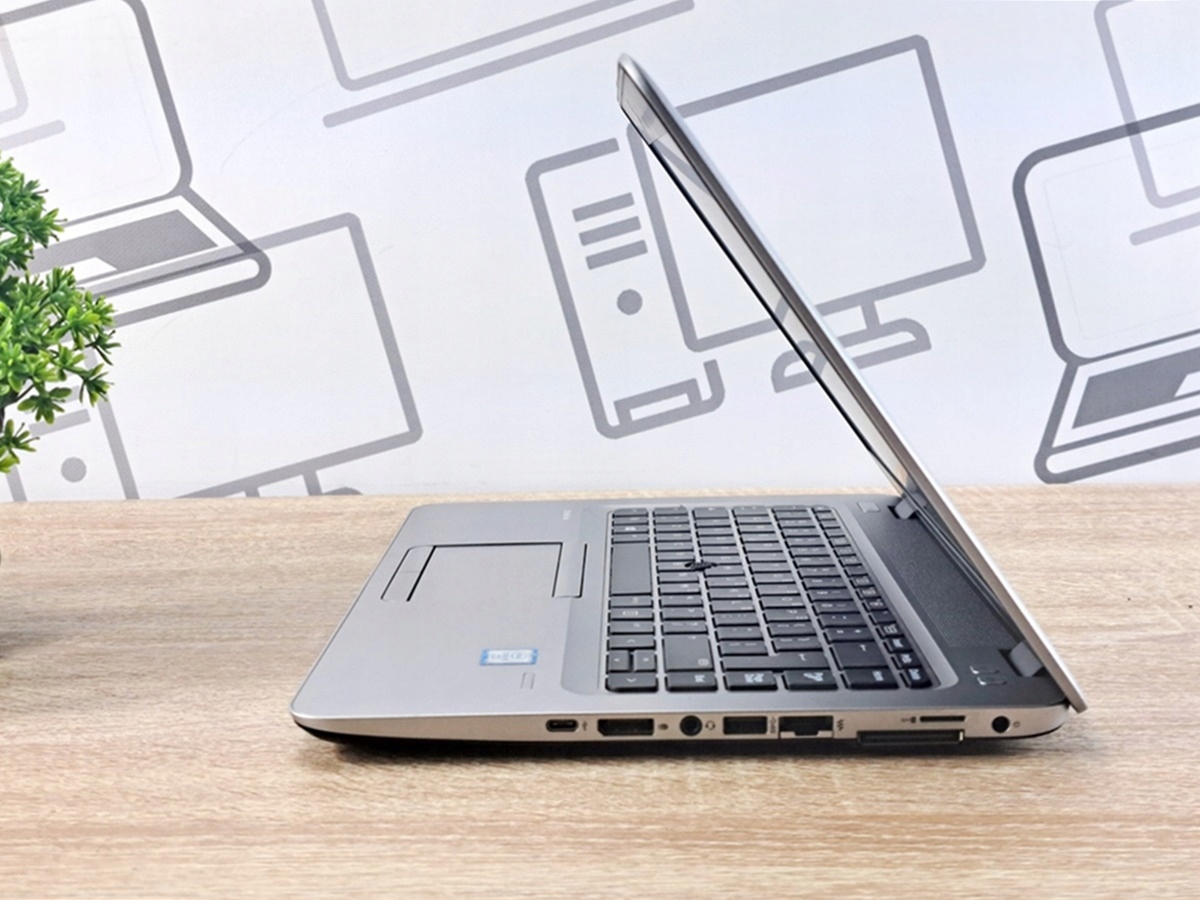 Laptop HP EliteBook 840 G3 uchylony pod kątem z boku, widoczna klawiatura i porty boczne, ekran wyłączony.