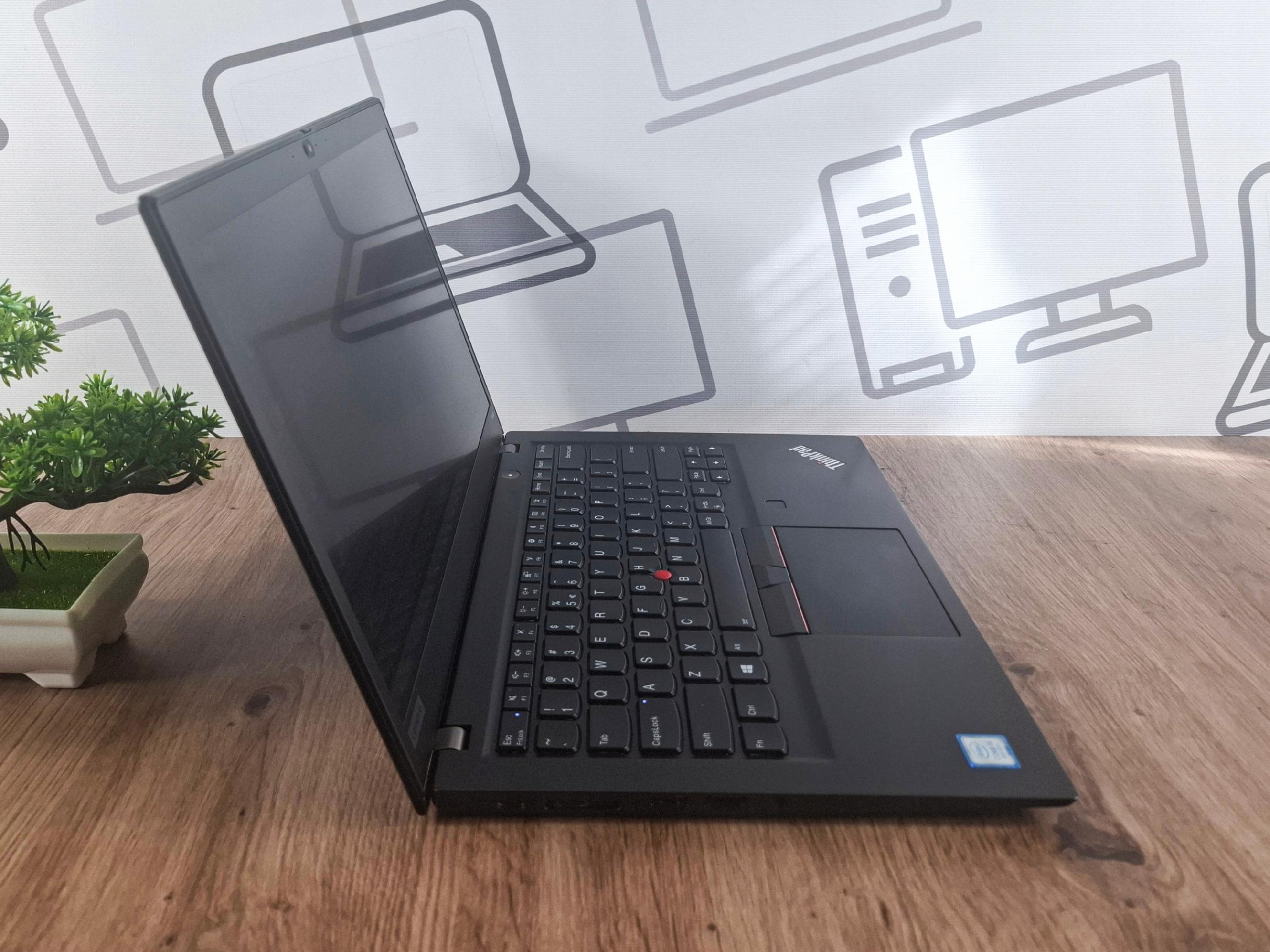 Otwarty laptop Lenovo ThinkPad T490s widoczny z boku pod kątem, czarna obudowa, ekran wyłączony, widoczna klawiatura.