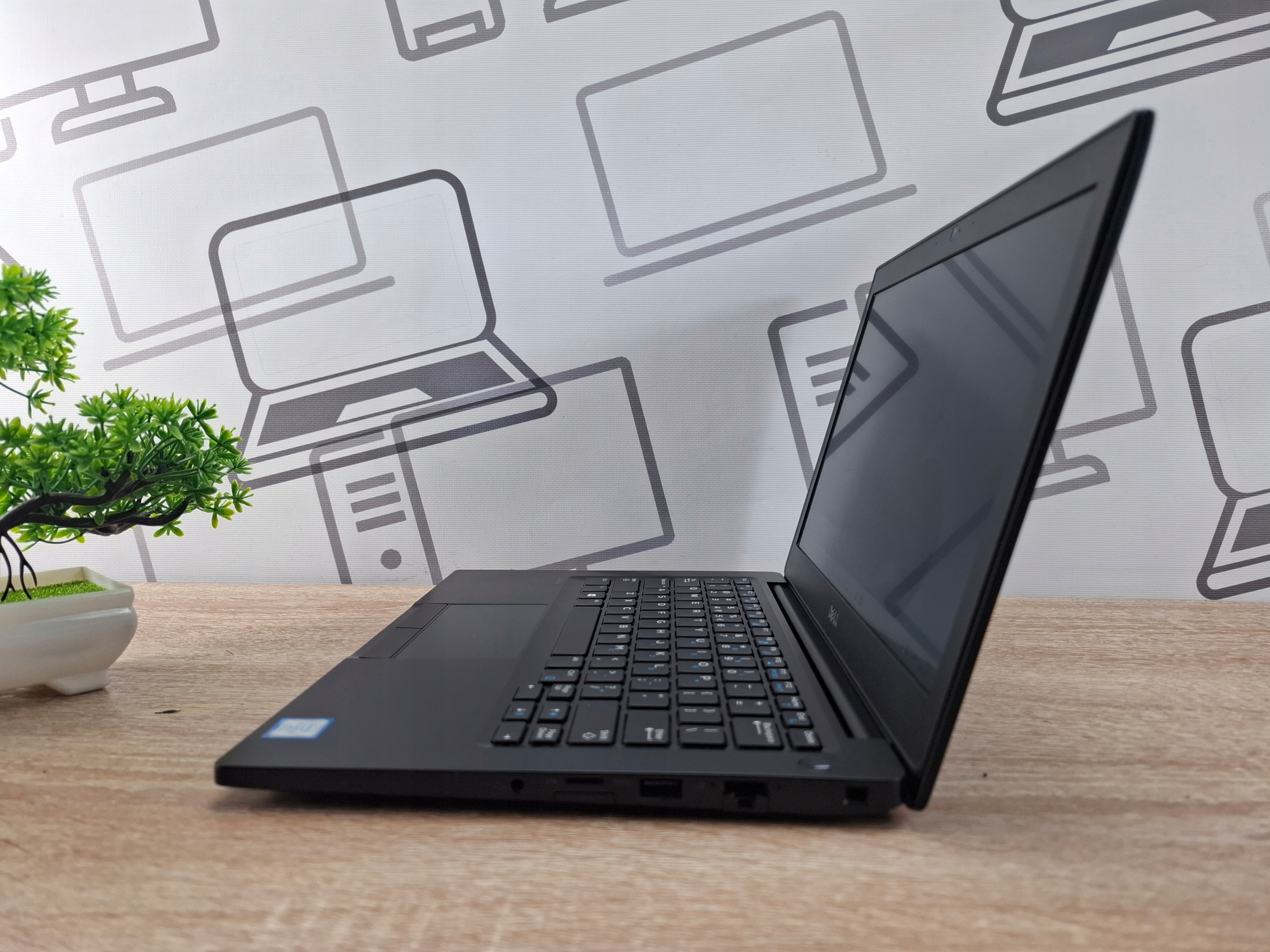 Laptop Dell Latitude 7280 otwarty pod kątem z boku, widoczna klawiatura, ekran i porty na lewej krawędzi obudowy.