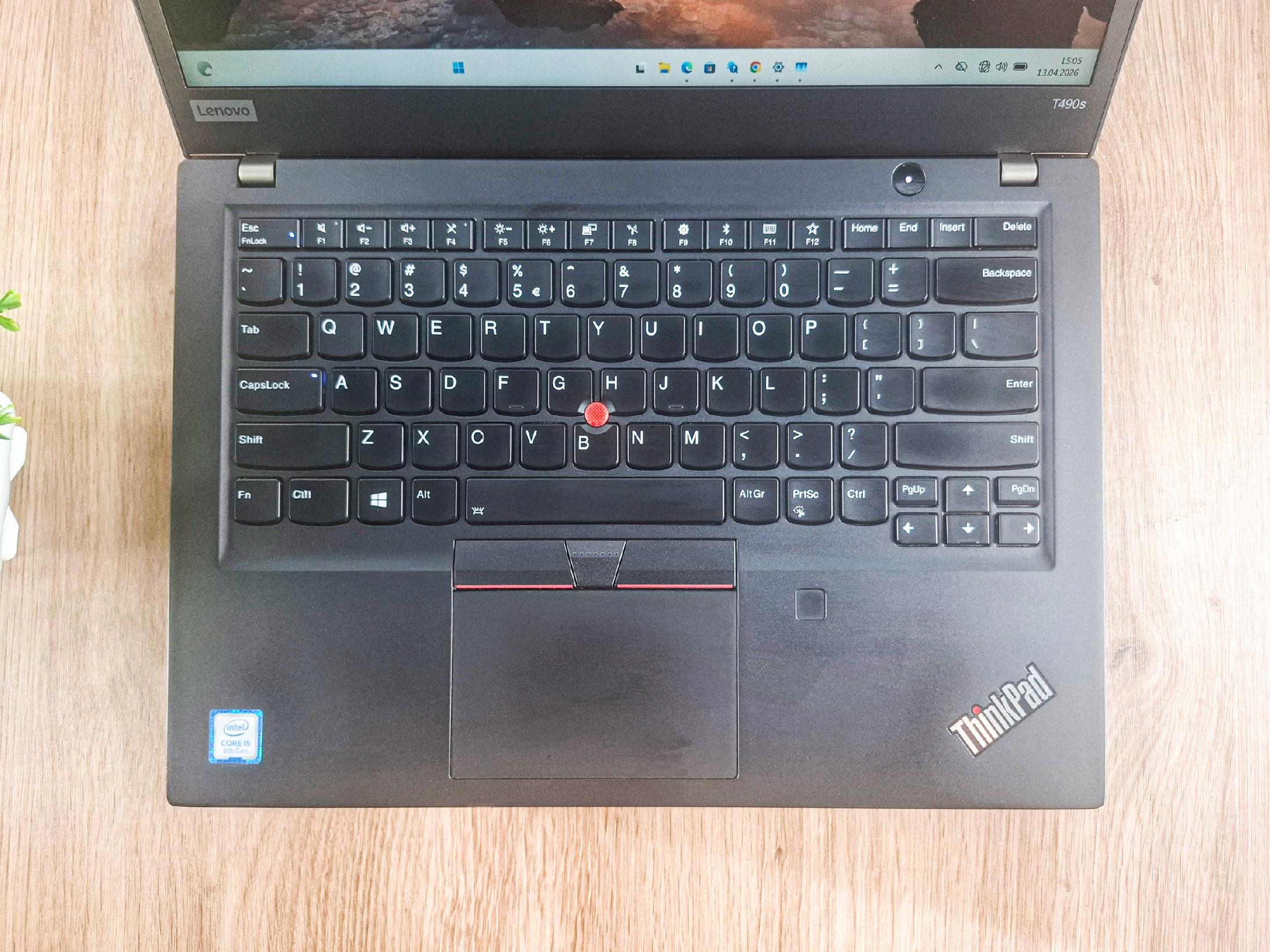 Otwarty laptop Lenovo ThinkPad widziany z góry, klawiatura z czerwonym trackpointem i touchpad w dobrym stanie.