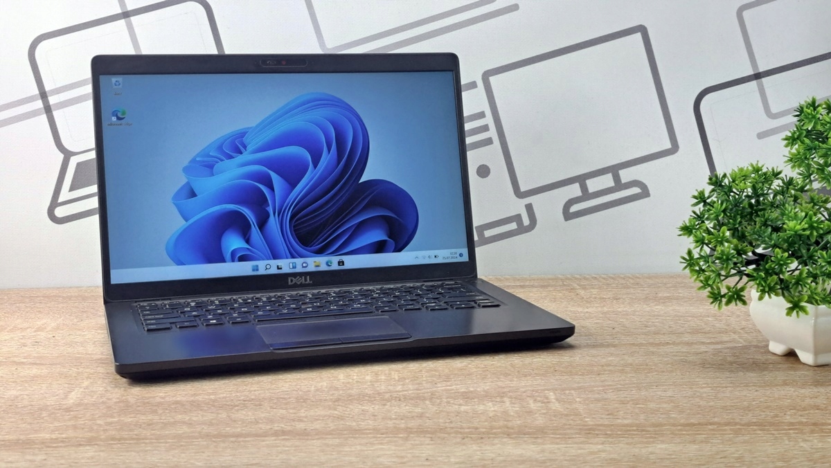 Otwarty laptop Dell Latitude 5400 pod kątem z boku, na ekranie logo Windows 11 na niebieskim tle.