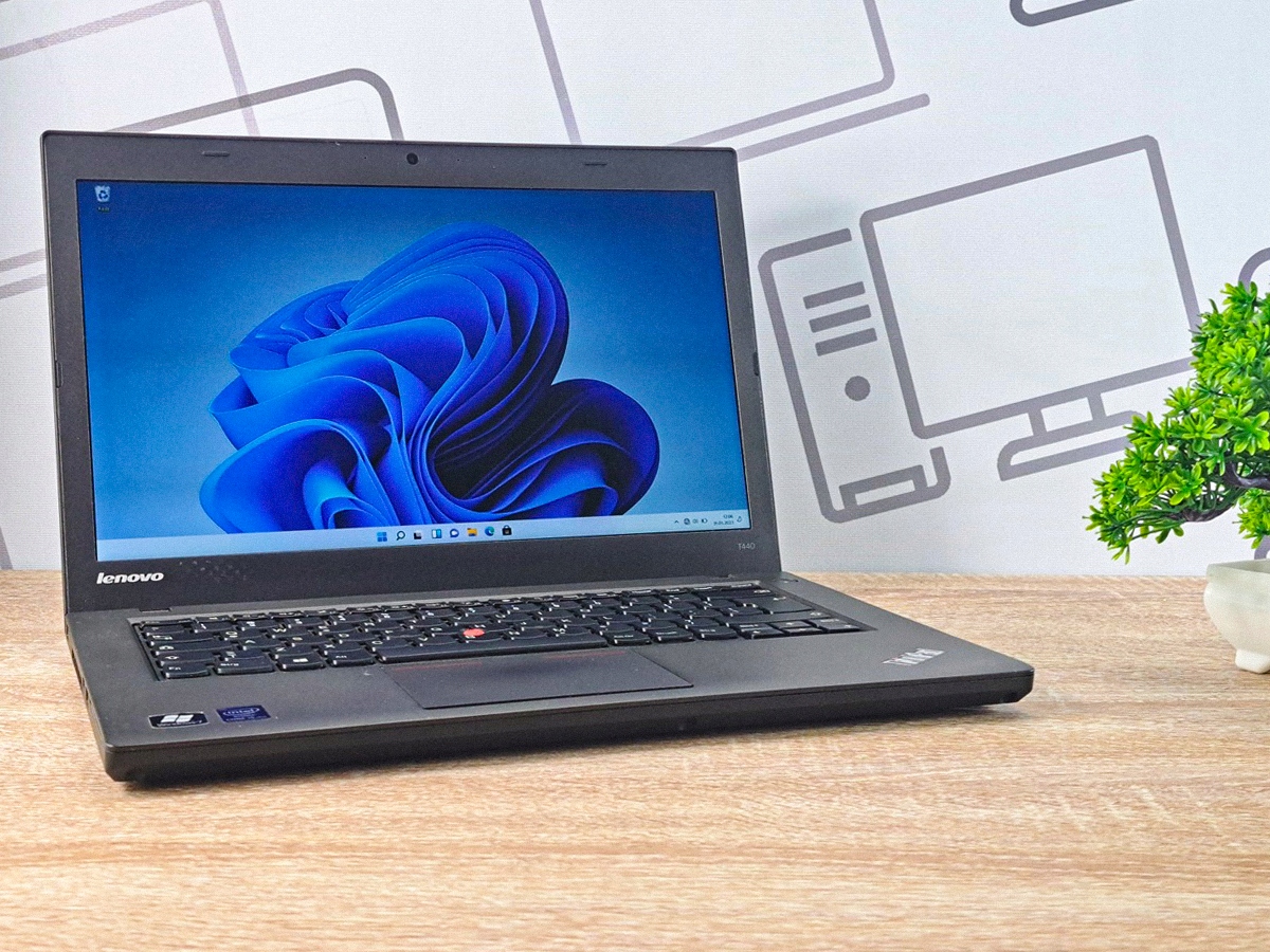 Otwarty laptop Lenovo ThinkPad T440 pod kątem z boku, ekran włączony z logo Windows 11, obudowa czarna matowa.