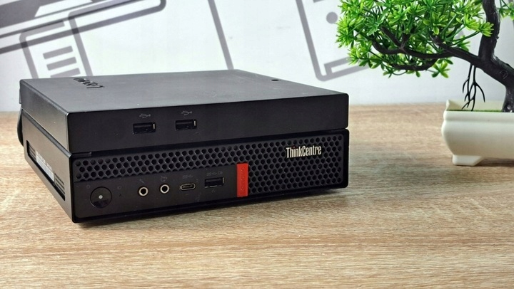 Przedni panel komputera Lenovo ThinkCentre Tiny z widocznymi portami USB, słuchawkowym i przyciskiem zasilania.