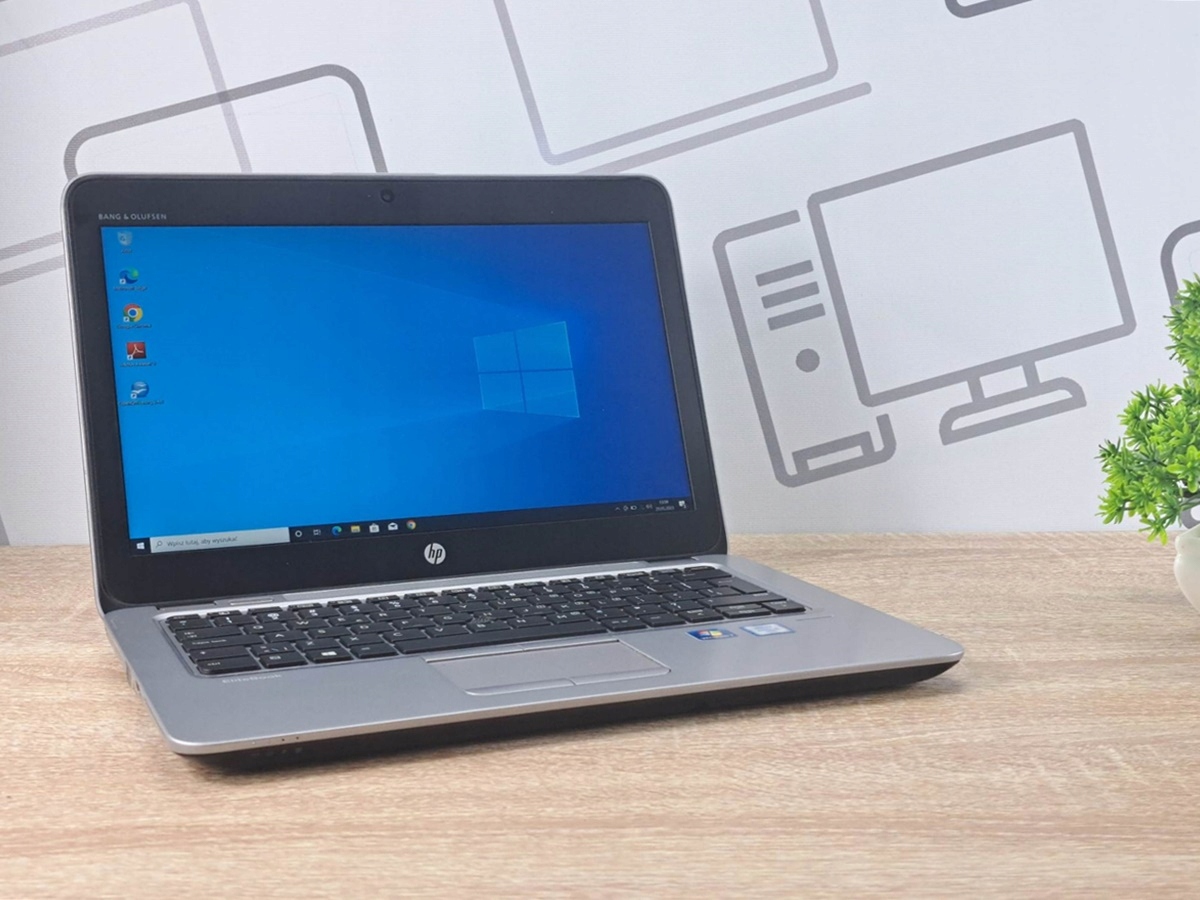 Otwarty laptop HP EliteBook 820 G3 pod kątem z boku, ekran włączony z pulpitem Windows 10.