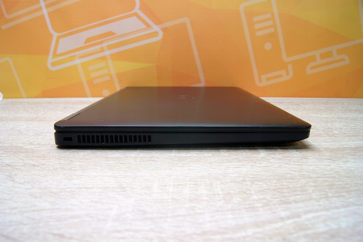 Zamknięty laptop Dell E7270 widziany z boku, widoczna kratka wentylacyjna na tylnej krawędzi obudowy.