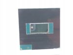 Zbliżenie na procesor Intel z widocznym metalowym rdzeniem pośrodku czarnej obudowy z pinami na spodzie.