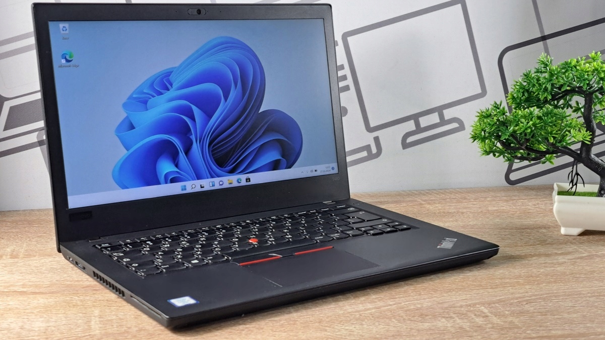 Laptop Lenovo ThinkPad T480 otwarty pod kątem z przodu, na ekranie kolorowa grafika systemu Windows