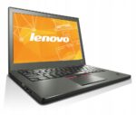 Otwarty laptop Lenovo ThinkPad X250 pod kątem z boku, na ekranie pomarańczowa grafika z logo Lenovo, widoczna klawiatura i touchpad.