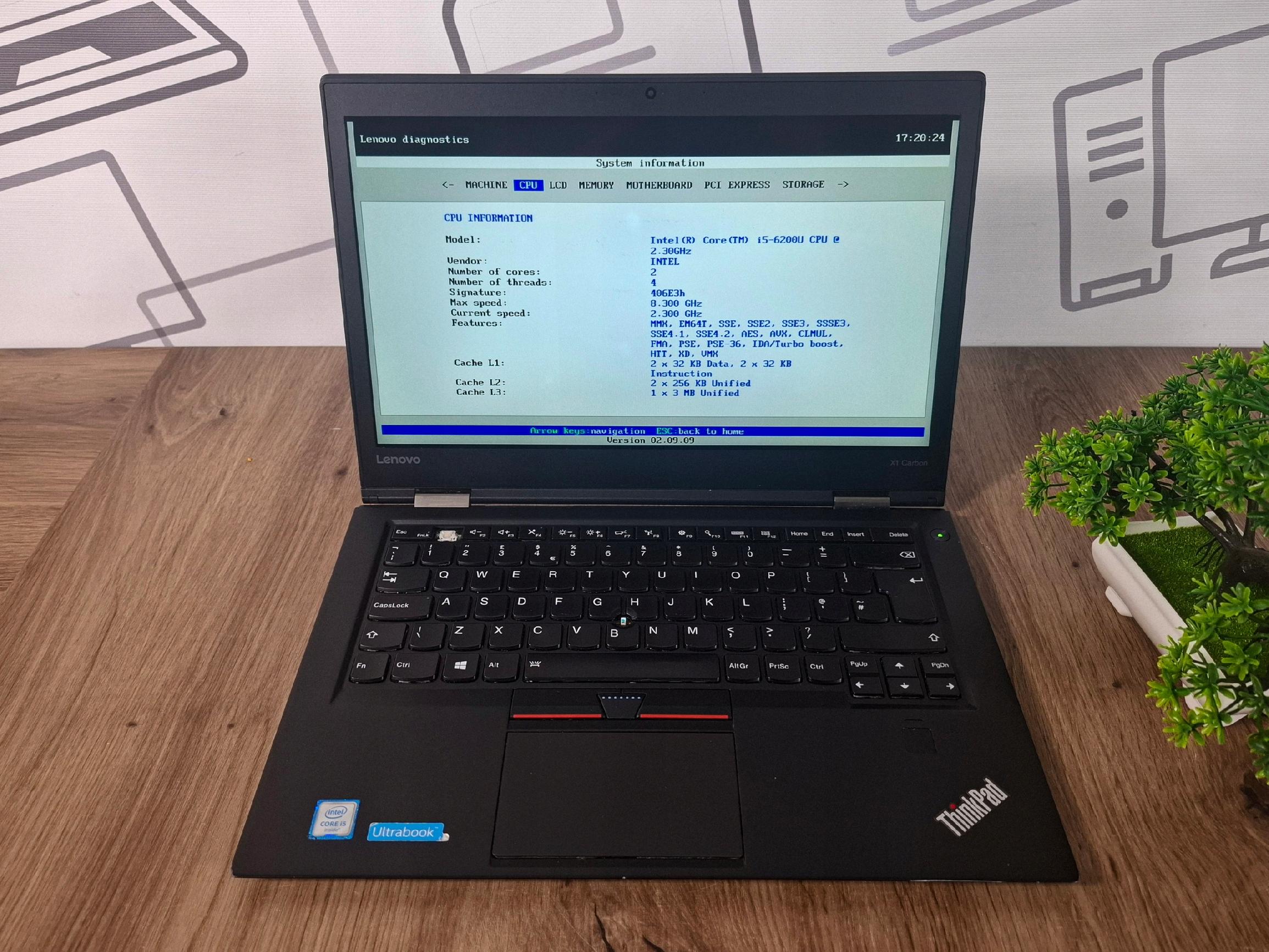 Otwarty laptop Lenovo ThinkPad X1 Carbon z ekranem BIOS-u, widoczna klawiatura i touchpad pod kątem z boku.