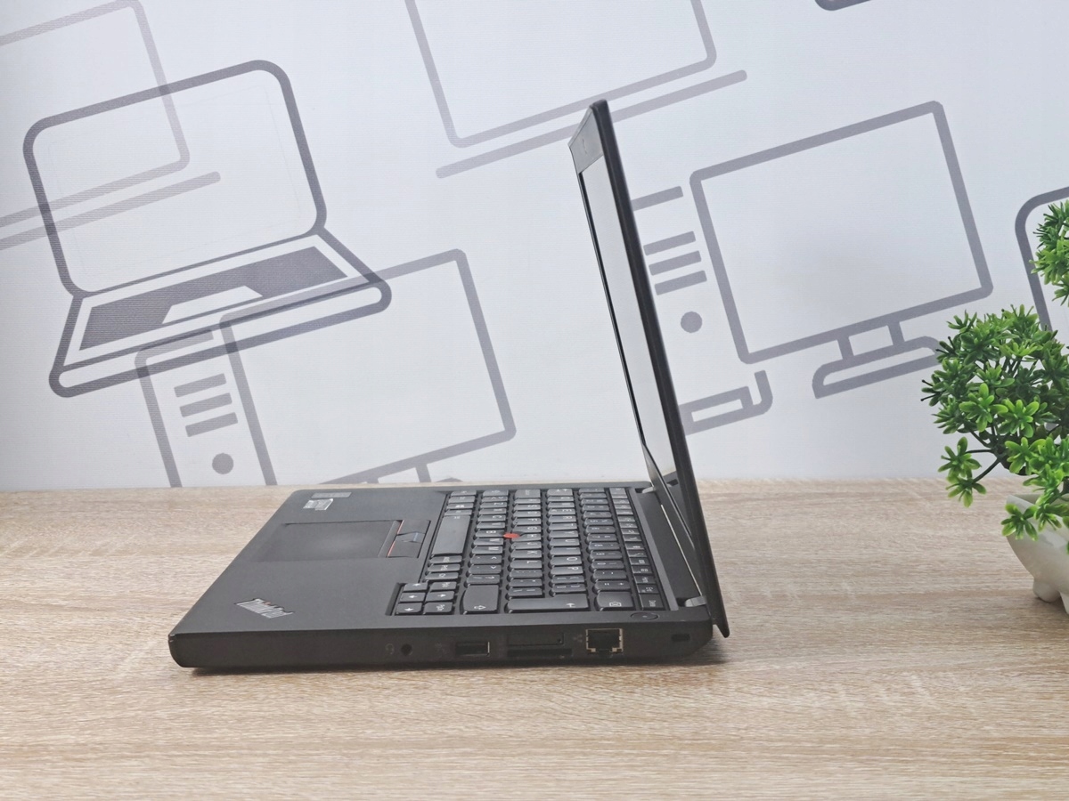 Laptop Lenovo ThinkPad X250 uchwycony z boku, częściowo otwarty, widoczne porty i czarna matowa obudowa.