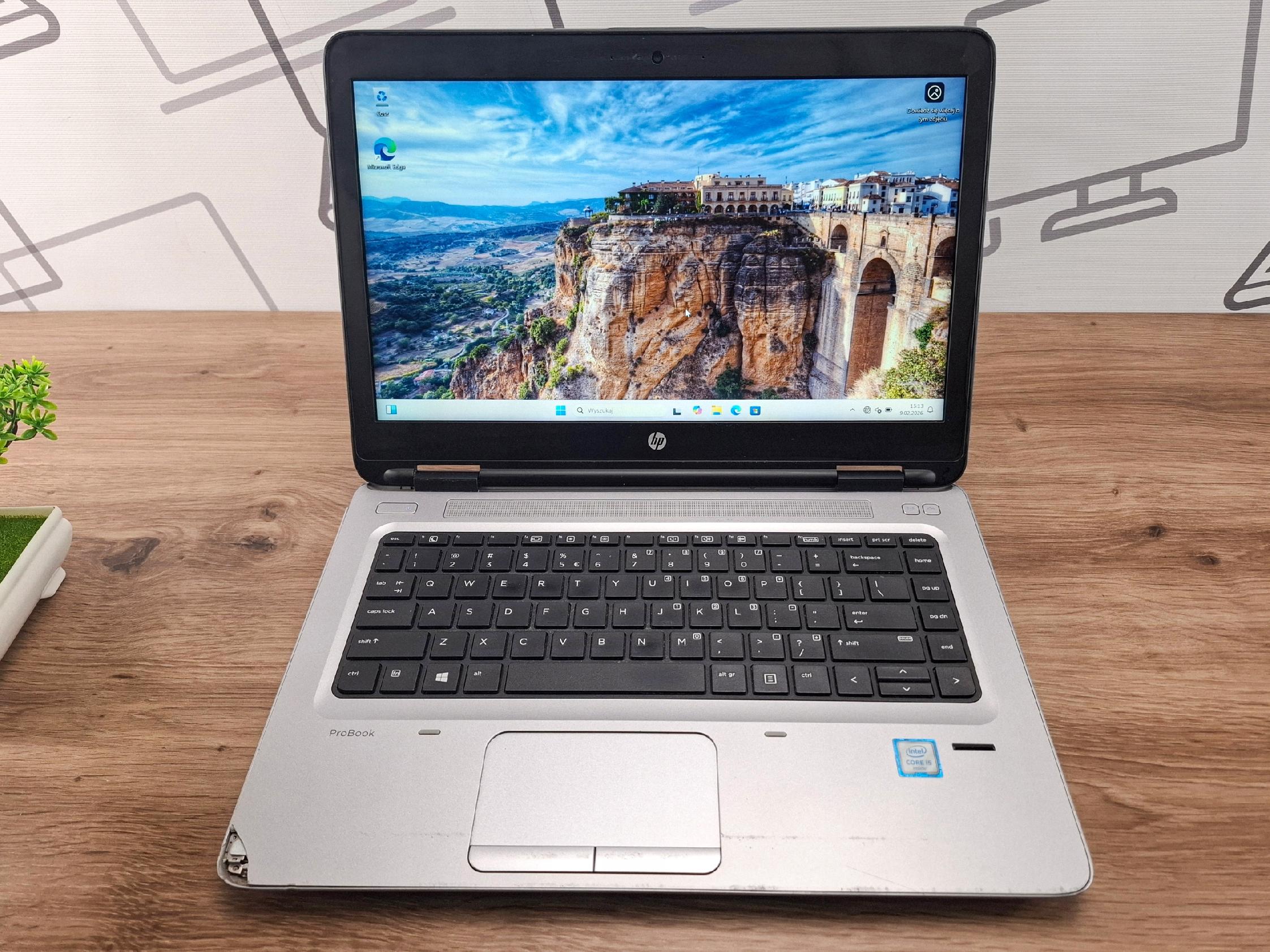 Laptop HP ProBook 640 G2 otwarty pod kątem z przodu, na ekranie widoczna tapeta z krajobrazem, obudowa lekko zarysowana.