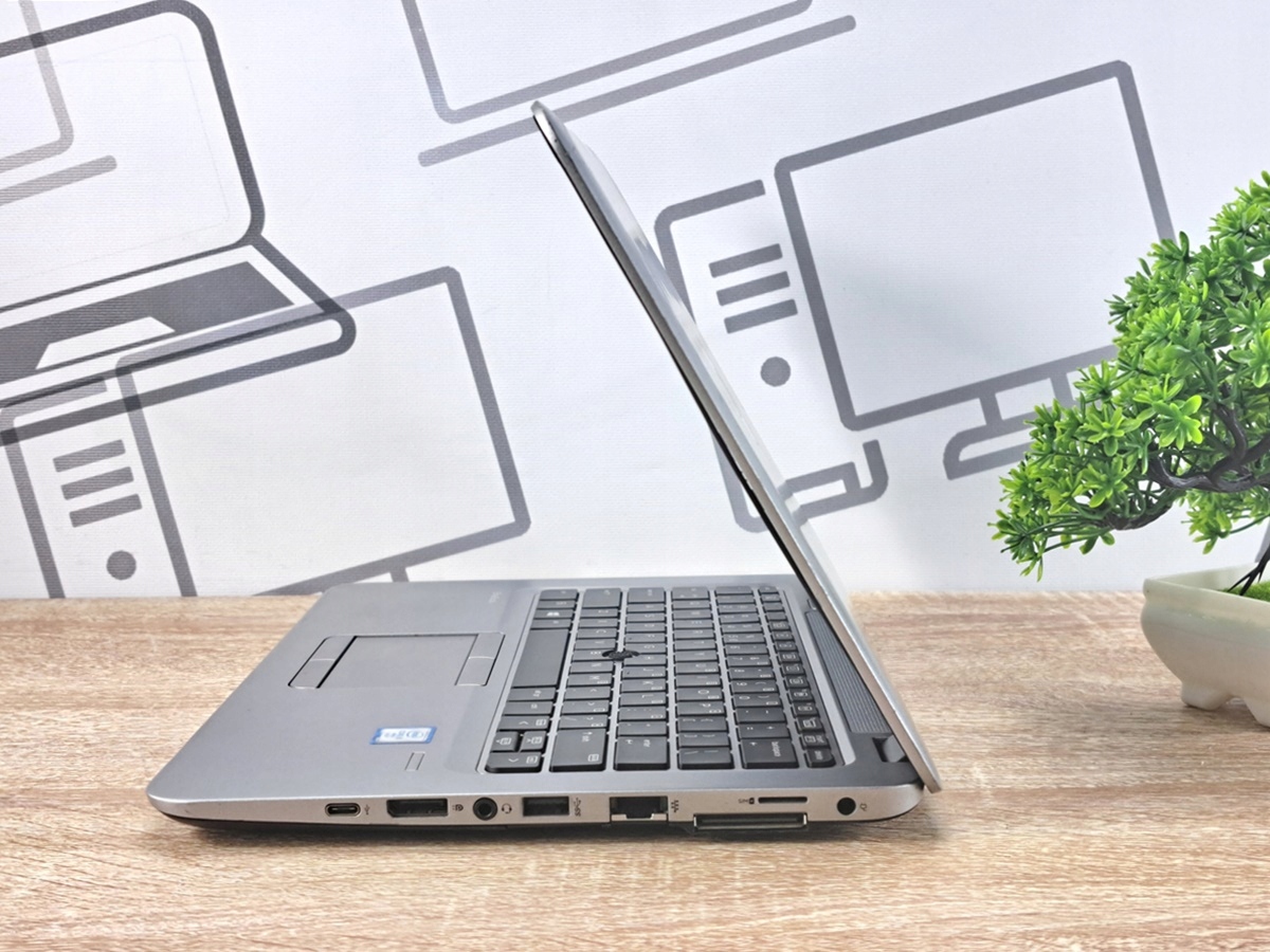 Laptop HP EliteBook 820 G3 lekko uchylony, widok z boku na klawiaturę i port RJ45 z diodami sieciowymi.