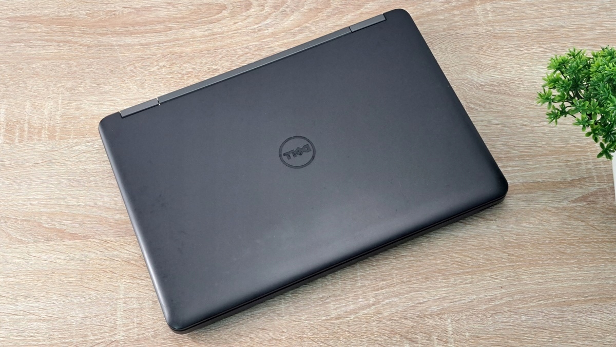 Zamknięty laptop Dell z logo na pokrywie, widok z góry pod kątem, obudowa lekko matowa z widocznymi śladami użytkowania.