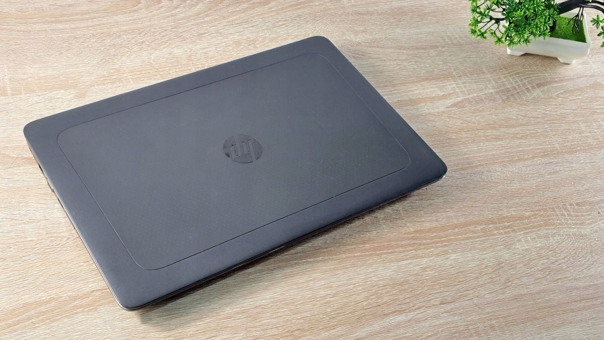 Zamknięty laptop HP ZBook widziany z góry pod kątem, matowa czarna obudowa z widocznym logo HP na wieku.