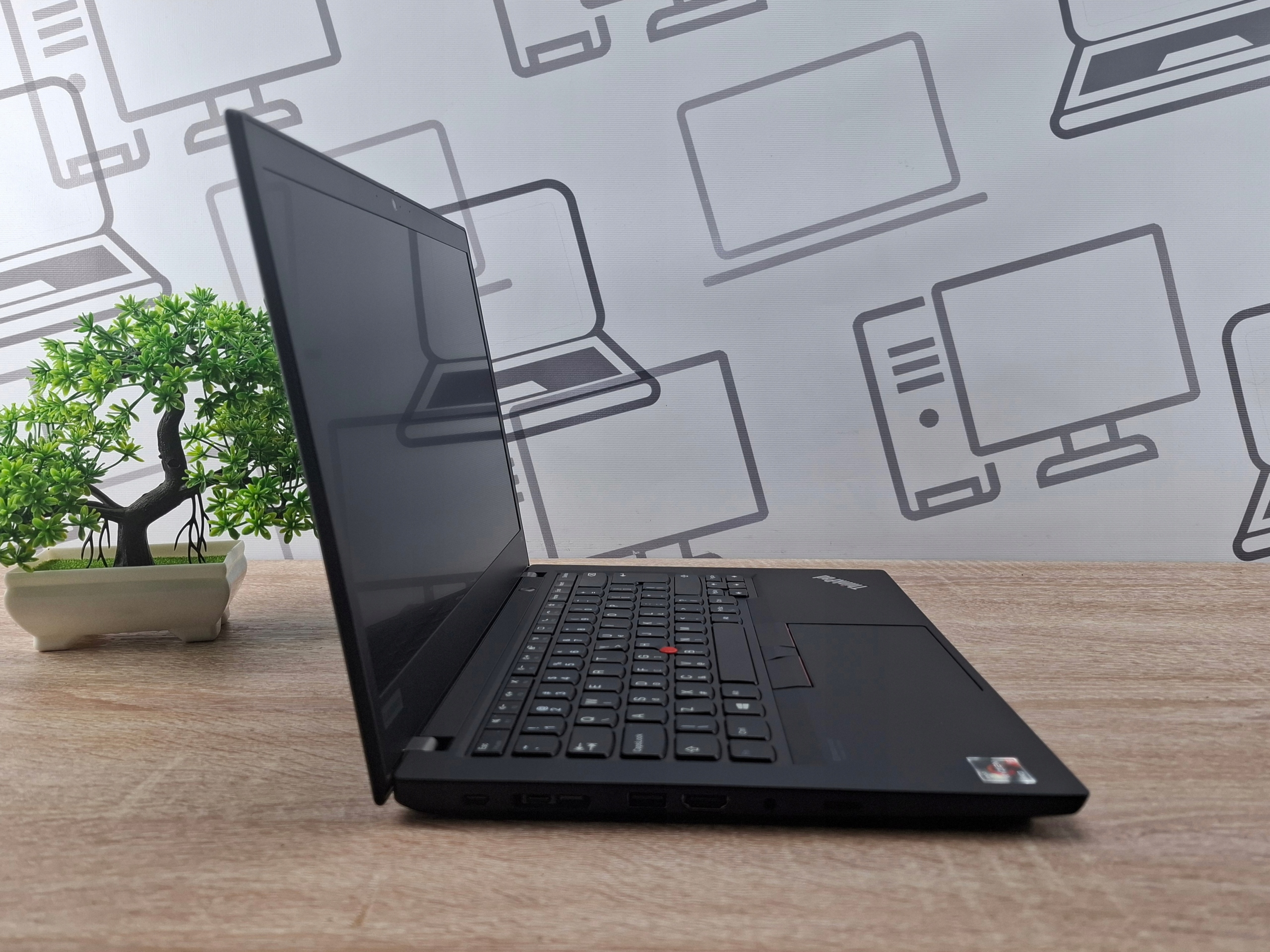 Laptop Lenovo ThinkPad T14 otwarty pod kątem z boku, widoczna klawiatura i lekko odchylony ekran