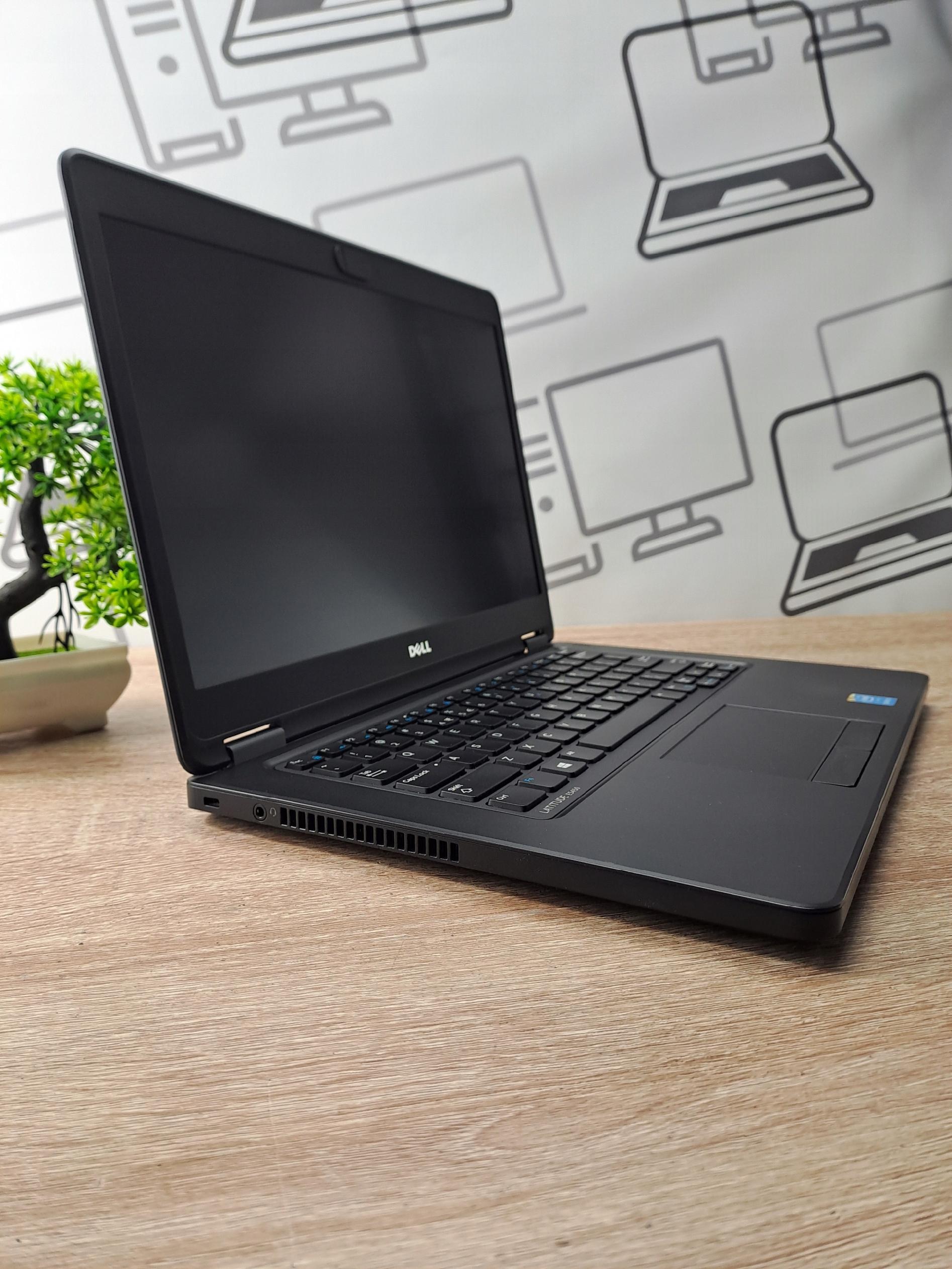 Laptop Dell Latitude E5450 otwarty pod kątem z boku, widoczna klawiatura i wygaszony ekran, obudowa w dobrym stanie.