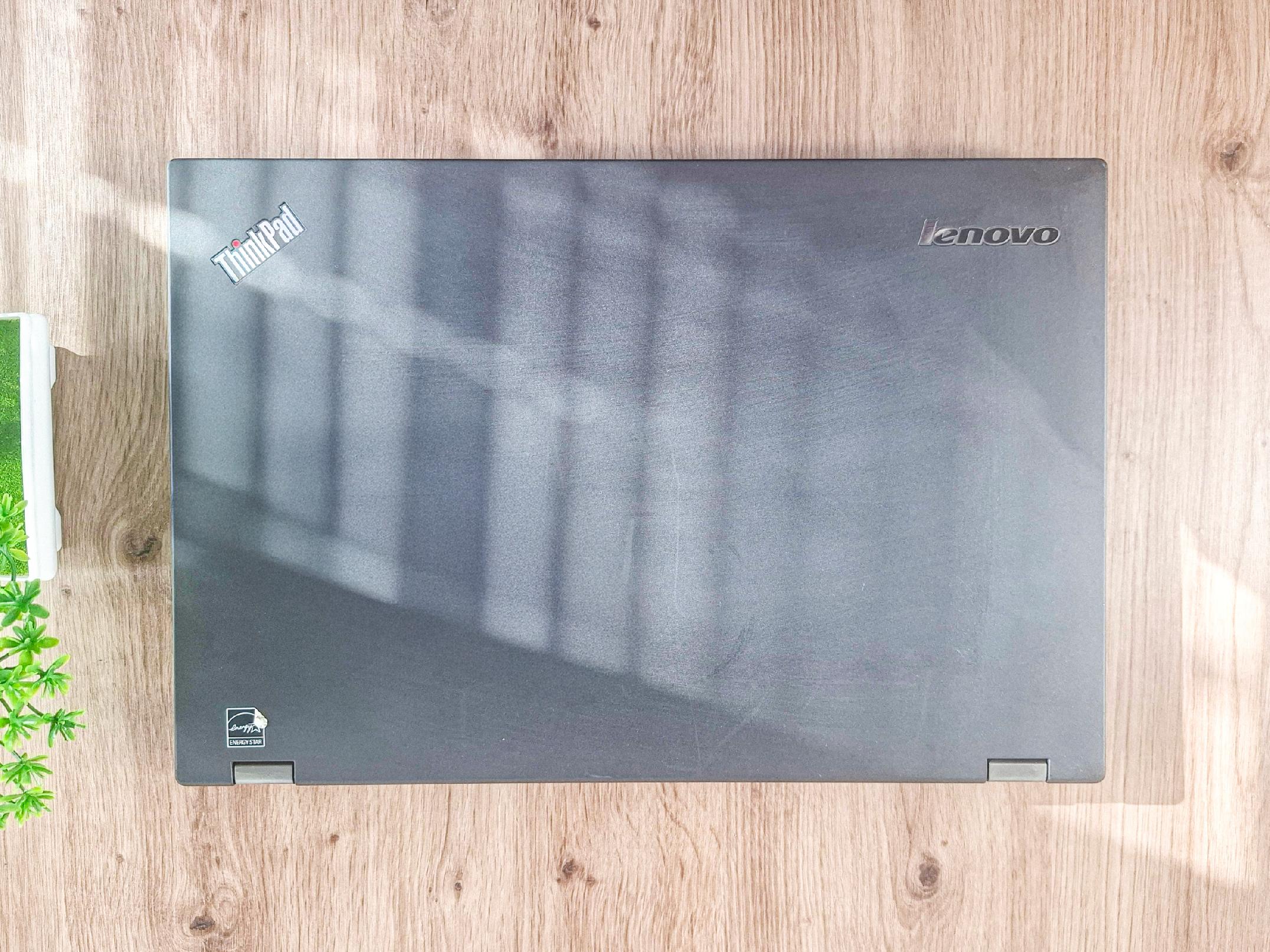 Zamknięta klapa laptopa Lenovo ThinkPad z widocznym logo, matowa obudowa z drobnymi śladami użytkowania.