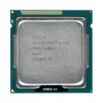 Procesor Intel Core i3-3240 widziany z góry, złota metalowa puszka ze oznaczeniami pośrodku zielonej płytki ze złotymi kontaktami.