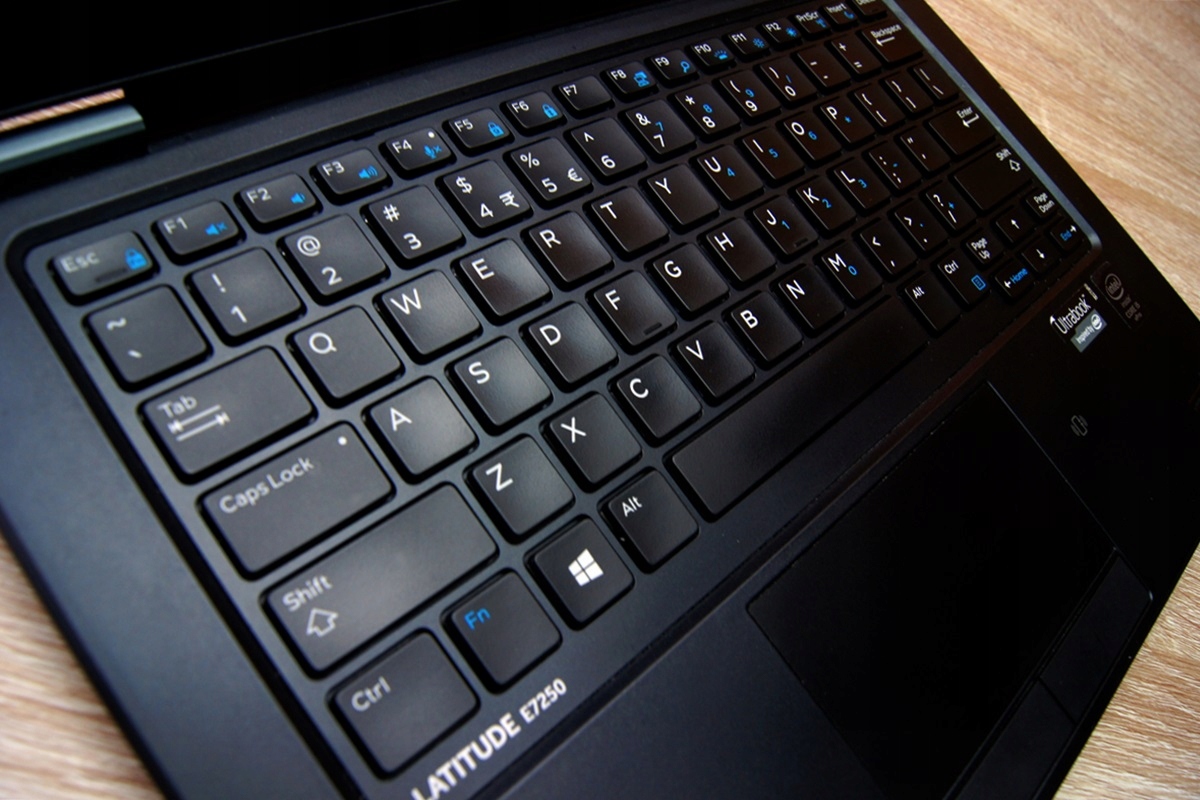 Otwarty laptop Dell Latitude E7250 z bliska, widok na klawiaturę i touchpad pod kątem z lewej strony.