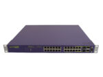 Przedni panel fioletowej obudowy switcha Extreme Networks z 24 portami RJ45 i dodatkowymi portami SFP z prawej strony.