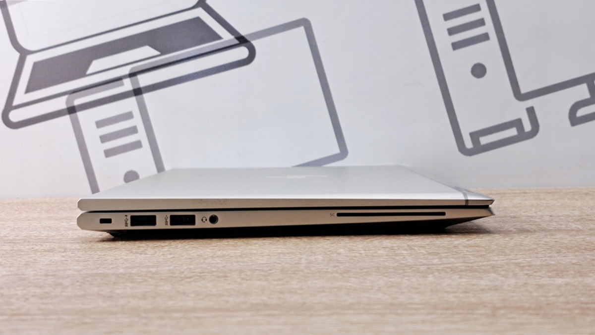 Zamknięty laptop HP EliteBook z boku, widoczne złącze zasilania, dwa porty USB i czytnik kart pamięci.