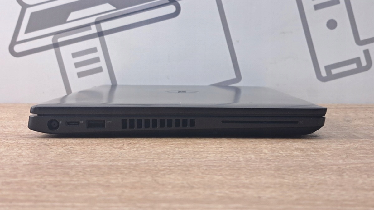 Lewy bok zamkniętego laptopa Dell Latitude z widocznym złączem zasilania, portem USB i kratką wentylacyjną.