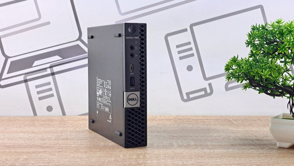 Mini komputer Dell 7050 Micro ustawiony pod kątem, widoczny bok obudowy z portami i naklejkami znamionowymi.