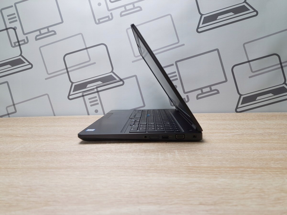 Laptop Dell Latitude 5580 uchylony pod małym kątem, widok z boku na zawias i porty na krawędzi obudowy.