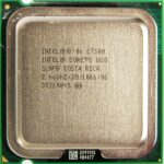 Zbliżenie procesora Intel Core 2 Duo E7300 w gniazdzie LGA775, widoczna metalowa powierzchnia z nadrukiem oznaczeń i złote krawędzie.