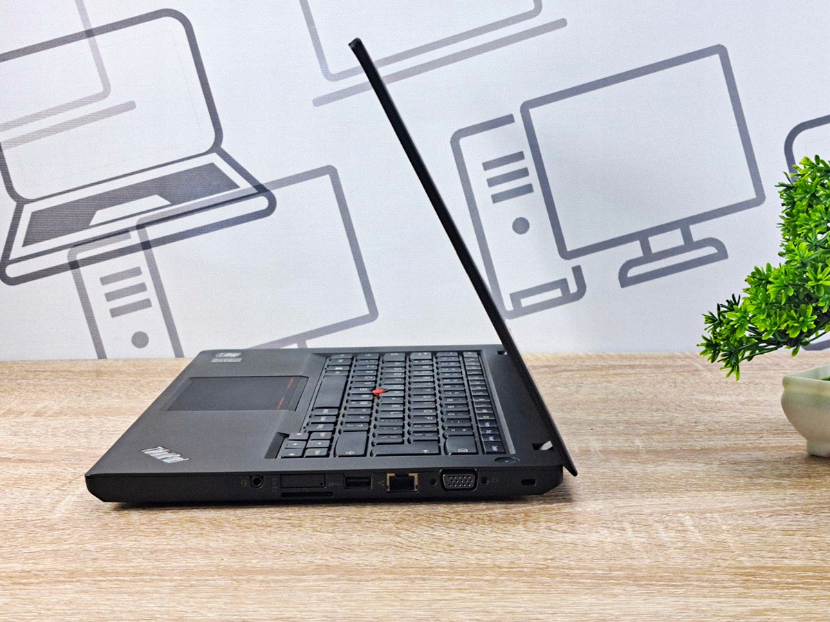 Laptop Lenovo ThinkPad T440 z boku, ekran uniesiony niemal do pełnego rozwarcia, widoczne porty i wąska ramka klawiatury.