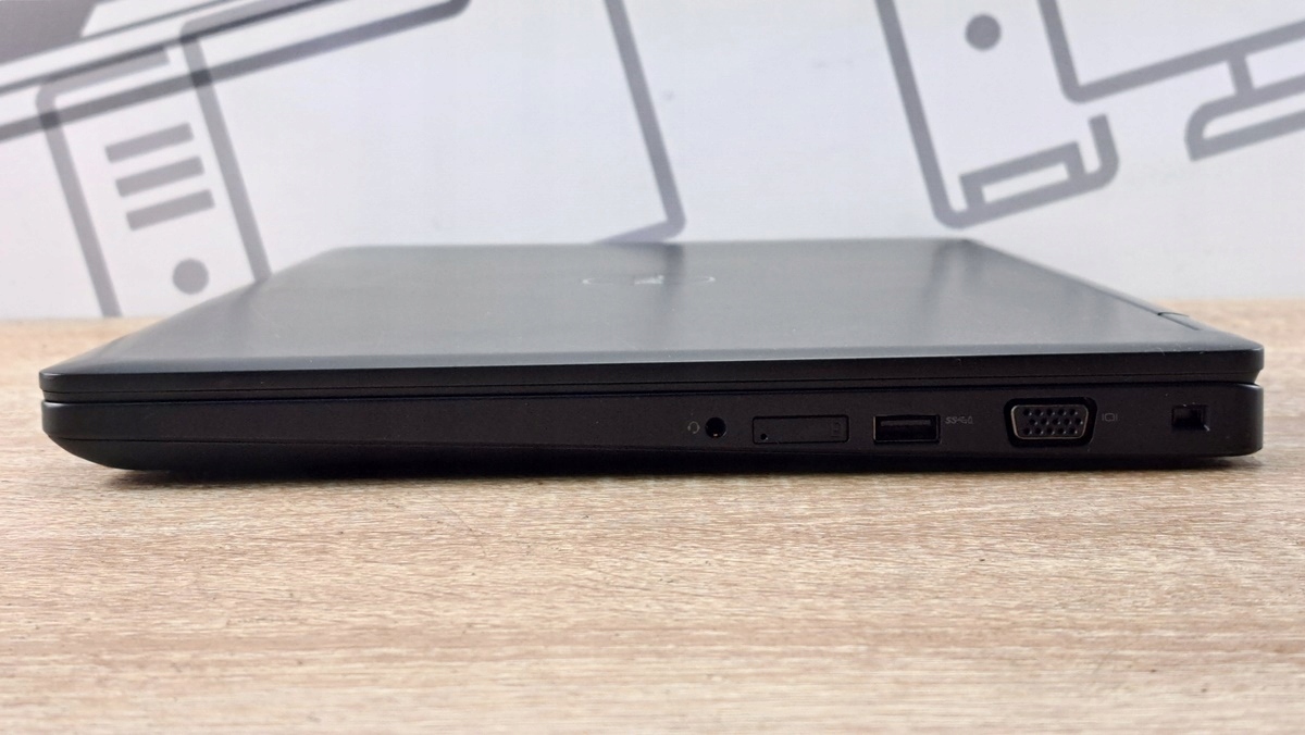 Prawy bok zamkniętego laptopa Dell Latitude 5590 z widocznym gniazdem audio, portem USB, złączem VGA i slotem blokady.