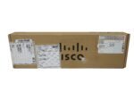 Zamknięte kartonowe pudełko Cisco z naklejkami wysyłkowymi i logo producenta z boku.