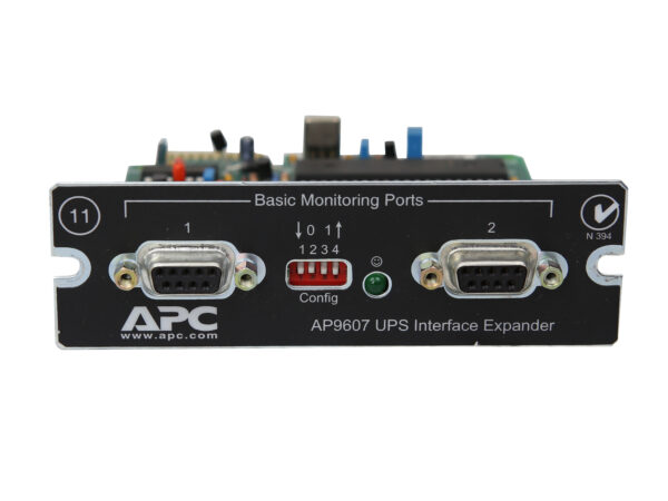 Moduł APC AP9607 z dwoma portami szeregowymi DB9, przełącznikiem konfiguracyjnym i płytką elektroniczną widoczną od góry.