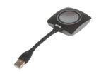 Przycisk Barco ClickShare z okrągłym przyciskiem na górze i wbudowanym, wygiętym kablem zakończonym wtyczką USB-A.